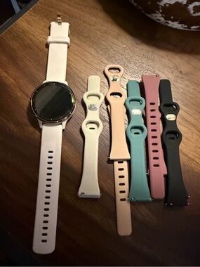 garmin white smartwatch with beige, blush, teal, mauve and black silicone bands